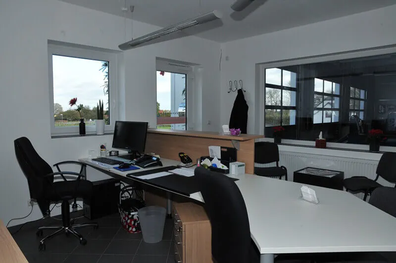 Empfangsbereich mit großer Panoramascheibe zur Werkstatt