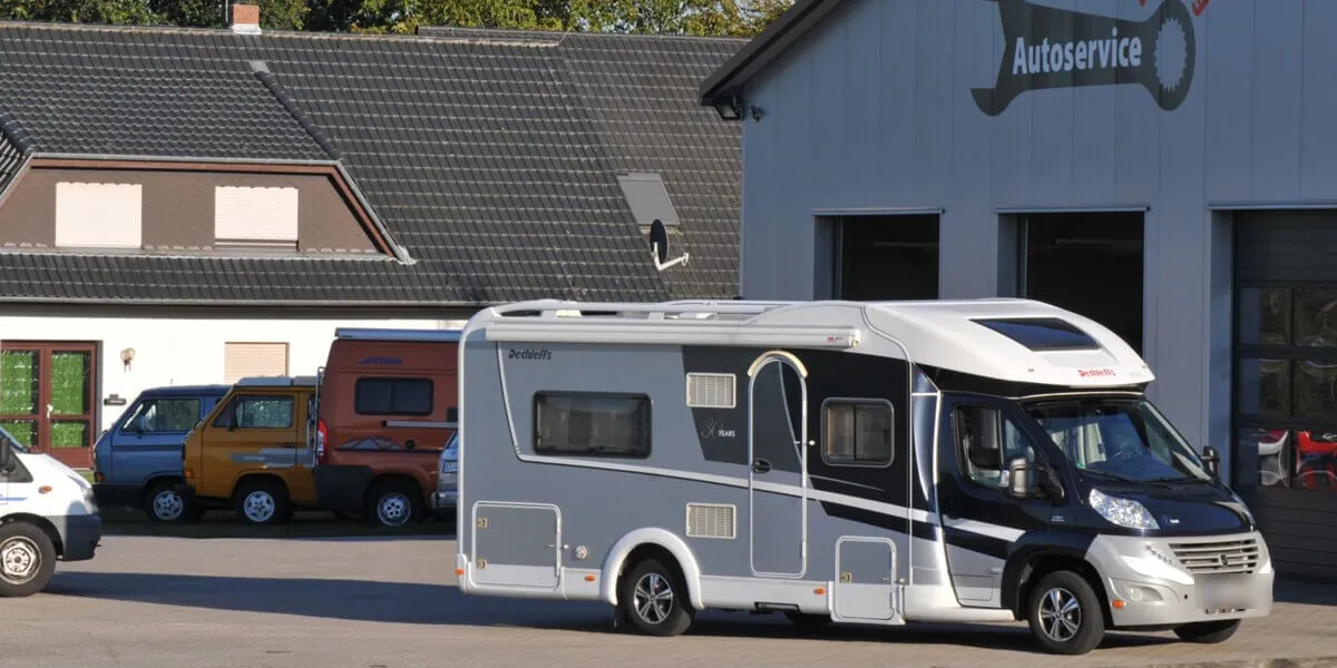 Reisemobil vor der Werkstatthalle des Autoservice am Berg